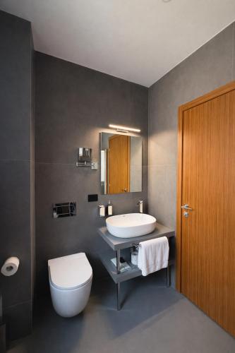a bathroom with a white toilet and a sink at J Maluni City Hotel in Rome