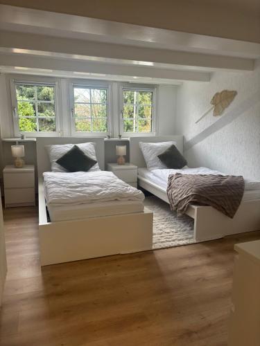 two beds in a bedroom with two windows at 115 qm Apartment für bis zu 8 Personen mit 4 Schlafzimmern in Lünen