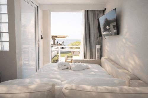 a bedroom with a white bed with a large window at Sela Lanta in Ko Lanta