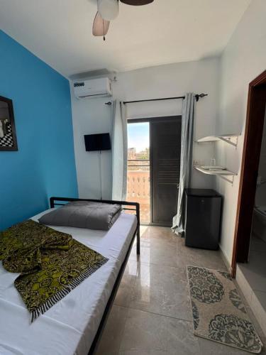 a bedroom with a bed with a blue wall at Hôtel La Maison Blanche in Saint-Louis