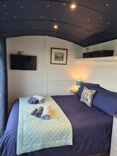a bedroom with a bed with two slippers on it at Shepherds Hut in Staithes