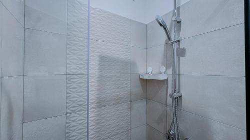 a shower with a glass door in a bathroom at The Loxwood House Studio in East Legon