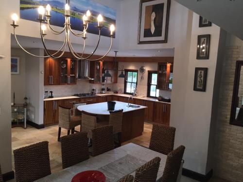 Una cocina con una mesa y sillas y una lámpara de araña. en De Zalze Luxury Lodge, en Stellenbosch