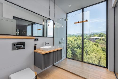 a bathroom with a sink and a large window at Gantiadi Holiday - Pool and Houses in Batumi
