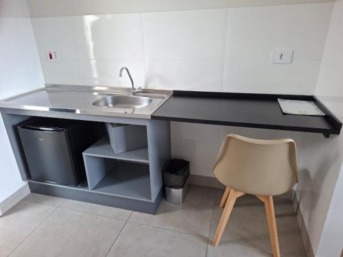 a desk with a sink and a chair in a room at NOBRE HOTEL COTIA in Cotia