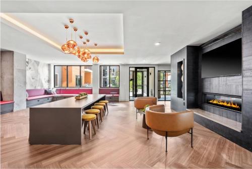 a living room with a fireplace and a dining room at Luxury Apartments by Hyatus Boston Somerville in Somerville