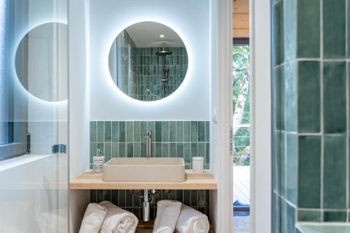 a bathroom with a sink and a mirror at Les Coteaux - Lodges & Expériences in Laparade