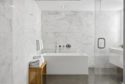 a white bathroom with a tub and a glass shower at Hotel Miami Beach Convention Center in Miami Beach