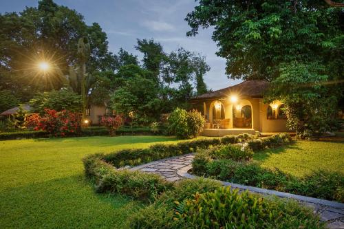 a house with a stone path in front of a yard at Green Mansions Jungle Resort in Sauraha