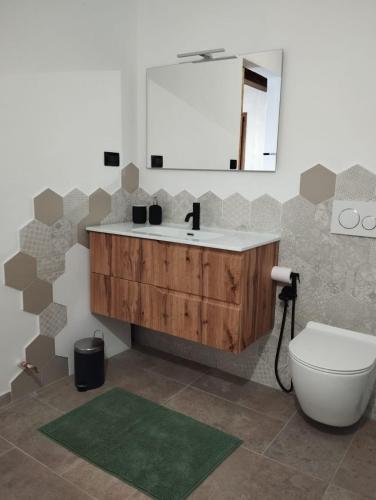 a bathroom with a sink and a toilet and a mirror at B&B Occhio di Adone in Monzuno