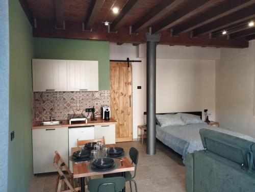 a bedroom with a bed and a table and a kitchen at B&B Occhio di Adone in Monzuno