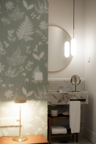 a bathroom with a sink and a mirror at NINE DOTS Azorean Art Boutique Hotel in Ponta Delgada