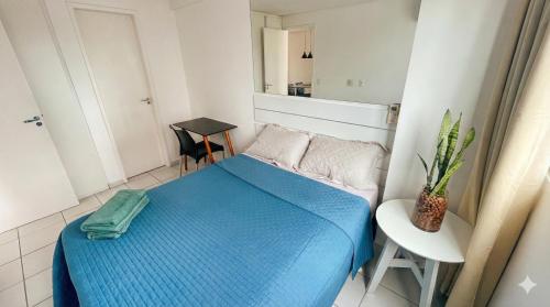 a small bedroom with a blue bed and a chair at Flat Jardins Madalena in Recife