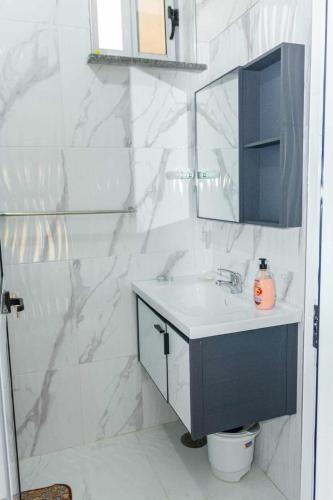 a white bathroom with a sink and a mirror at Hospedaria Santo António 2 in Praia Baixo