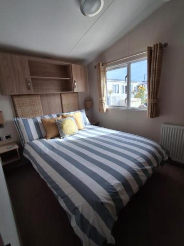 a large bed in a bedroom with a window at Beachside Heacham in Heacham