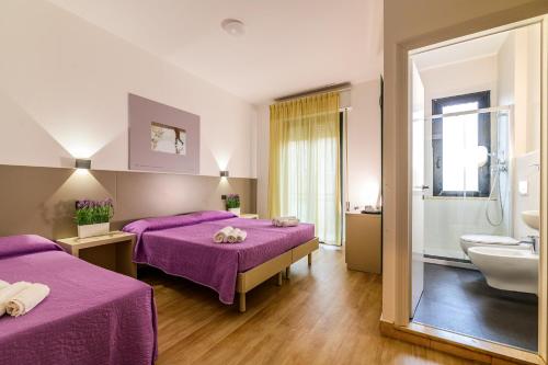 a hotel room with two beds and a bathroom at Vinsea Hotel in Bellaria-Igea Marina