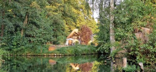 a house on the side of a river with trees at Kauperhaus in Burg
