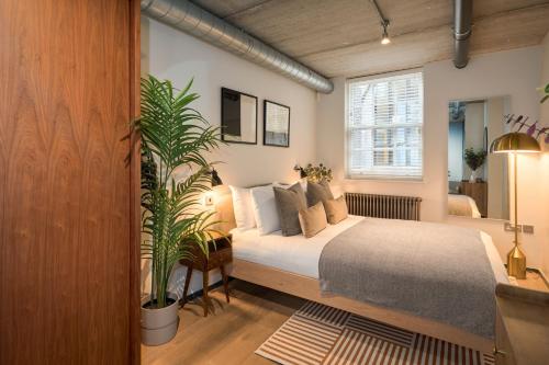 a bedroom with a bed and a plant in it at Be London - The Southwark Residences in London
