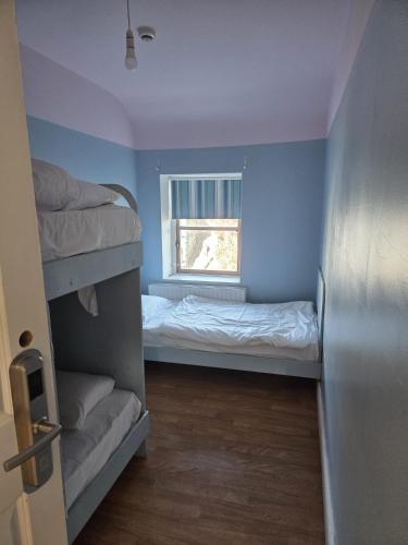 a small room with a bunk bed and a window at Hacketts Bar And Accommodation in Kilkenny