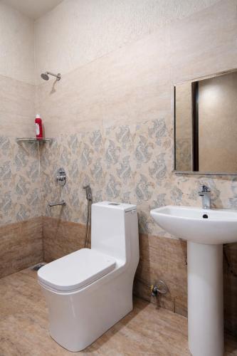 a bathroom with a toilet and a sink at Hotel V N Ganga in Rishīkesh