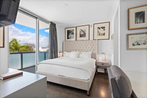 a white bedroom with a bed and a large window at Hotel Miami Beach Convention Center in Miami Beach