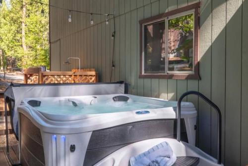 a bath tub in a room with a window at Cozy Cabin - Hot Tub, Fire Pit, & Pets in Arnold