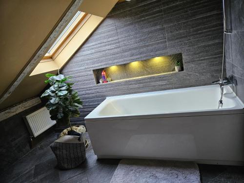 a white bath tub in a bathroom with a brick wall at Laci Lak in Oradea