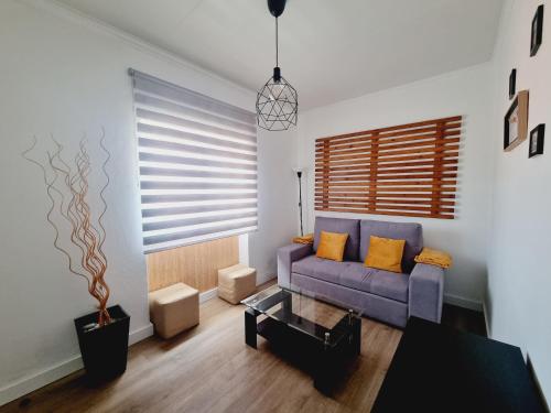 a living room with a purple couch and a table at Family Surf Home - Casa do Sol in Mafra