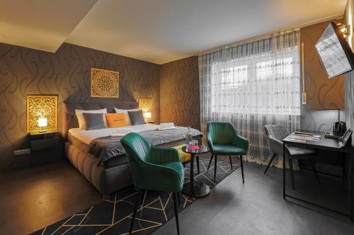 a bedroom with a bed and a desk and chairs at DUA Hotel in Sarstedt
