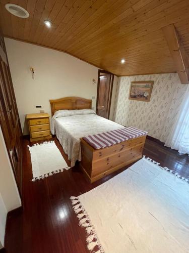 a bedroom with a bed and a wooden ceiling at Hotel Victorino in Silleda