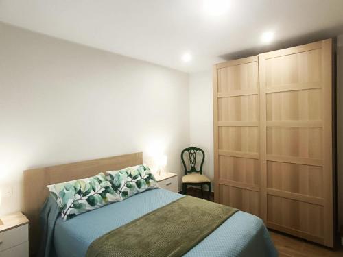 a bedroom with a bed and a cabinet and a chair at Apartamentos Rurales Sariar in Villar