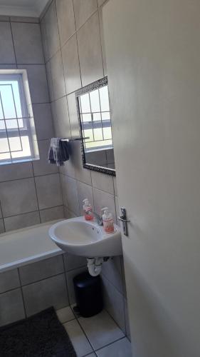 a bathroom with a sink and a tub and a window at Riley's Place in Cape Town