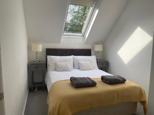 a bedroom with a bed with two pillows on it at Lakescape in Cirencester