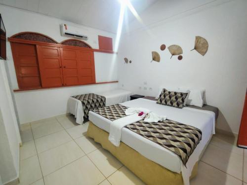 a bedroom with two beds in a room with umbrellas on the wall at POUSADA LUATOUR Praia Pontal do Coruripe in Coruripe
