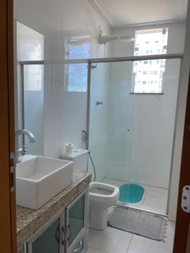 a bathroom with a sink and a toilet and a shower at Dois quartos centro in Ubá