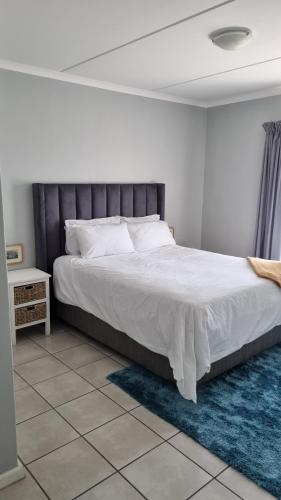 a bedroom with a large bed and a blue rug at Riley's Place in Cape Town