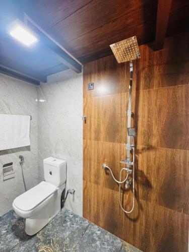 a bathroom with a toilet and a shower at Sinharaja Brook Cabana in Deniyaya