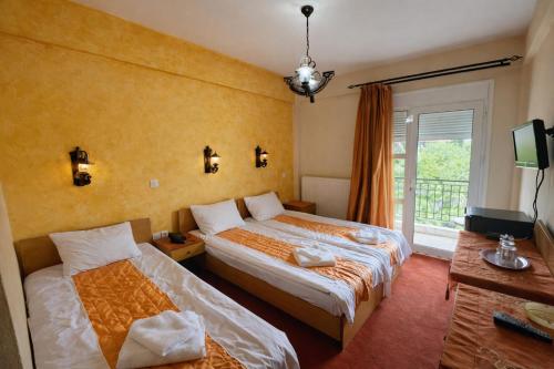 a hotel room with two beds and a window at Ducata Hotel - Xirolivado in Xirolívadon