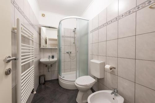 a white bathroom with a toilet and a sink at Apartments Dorijan with Pool in Matulji