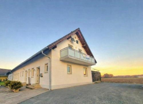 a house with a balcony on top of it at Loipersdorf Living - Golf & Therme in Loipersdorf bei Fürstenfeld