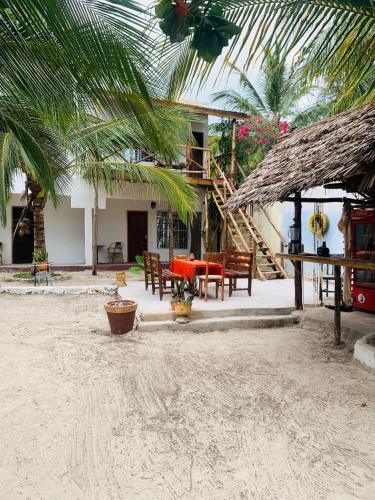 un complexe avec une table et des chaises sur la plage dans l'établissement Paje lounge, à Paje