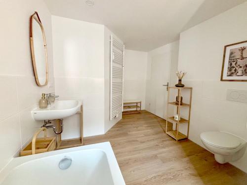 a white bathroom with a sink and a toilet at Ferienwohnung La Bohème in Bad Königshofen im Grabfeld