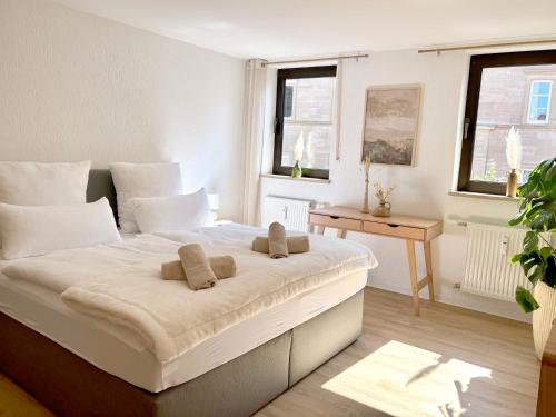 a bedroom with a large white bed with two pillows at Ferienwohnung La Bohème in Bad Königshofen im Grabfeld