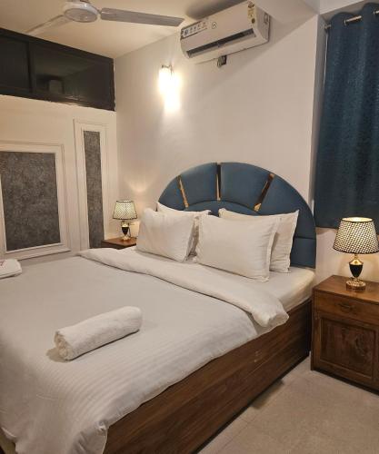 a bedroom with a large bed with a blue headboard at Villa platinum 4 Bhk in Calangute