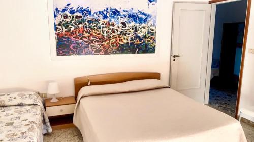 a bedroom with a bed and a painting on the wall at RM05 - Senigallia, trilocale fronte mare in Senigallia
