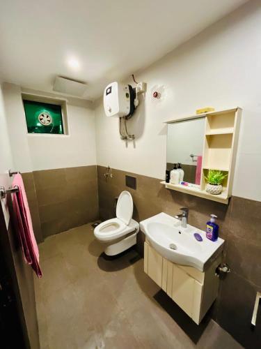 a bathroom with a white toilet and a sink at Bahria 777 Luxury Apartment in Lahore