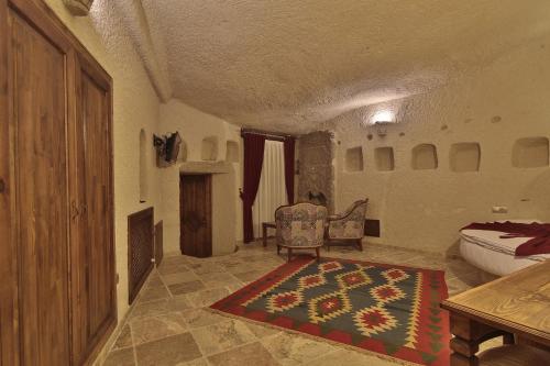 a room with a bedroom with a bed and a rug at Vezir Cave Suites in Goreme