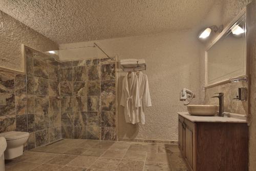 a bathroom with a shower and a sink and a toilet at Vezir Cave Suites in Goreme
