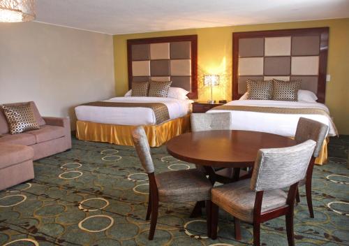 a hotel room with two beds and a table and a couch at Gateway Inn and Suites in Salida