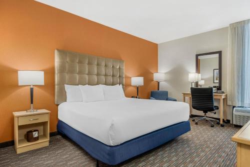 a hotel room with a large bed and a desk at Pear Tree Inn Cape Girardeau West in Cape Girardeau